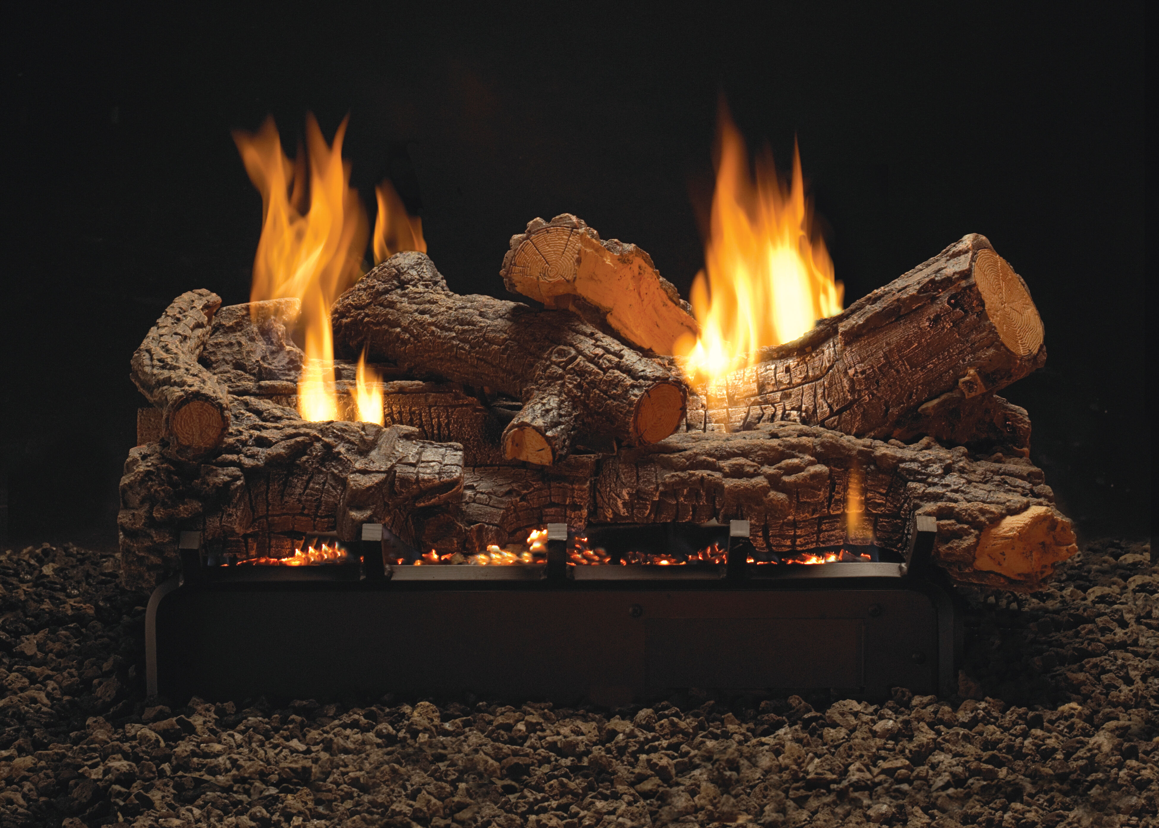 A Ventless gas log set burning on top of a modern black fireplace grate.